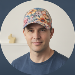 Soren K. smiling and wearing the AQUAREN Watercolor Floral Baseball Cap, featuring colorful watercolor flowers. His head and 